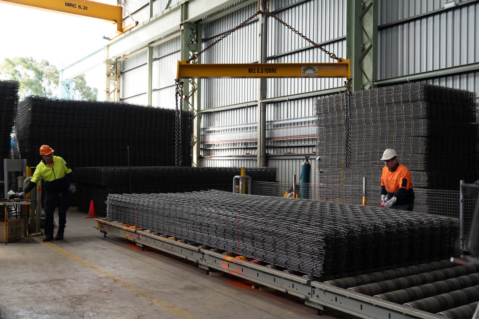 Two Bianco team members working on a stack of reinforcing mesh in the factory