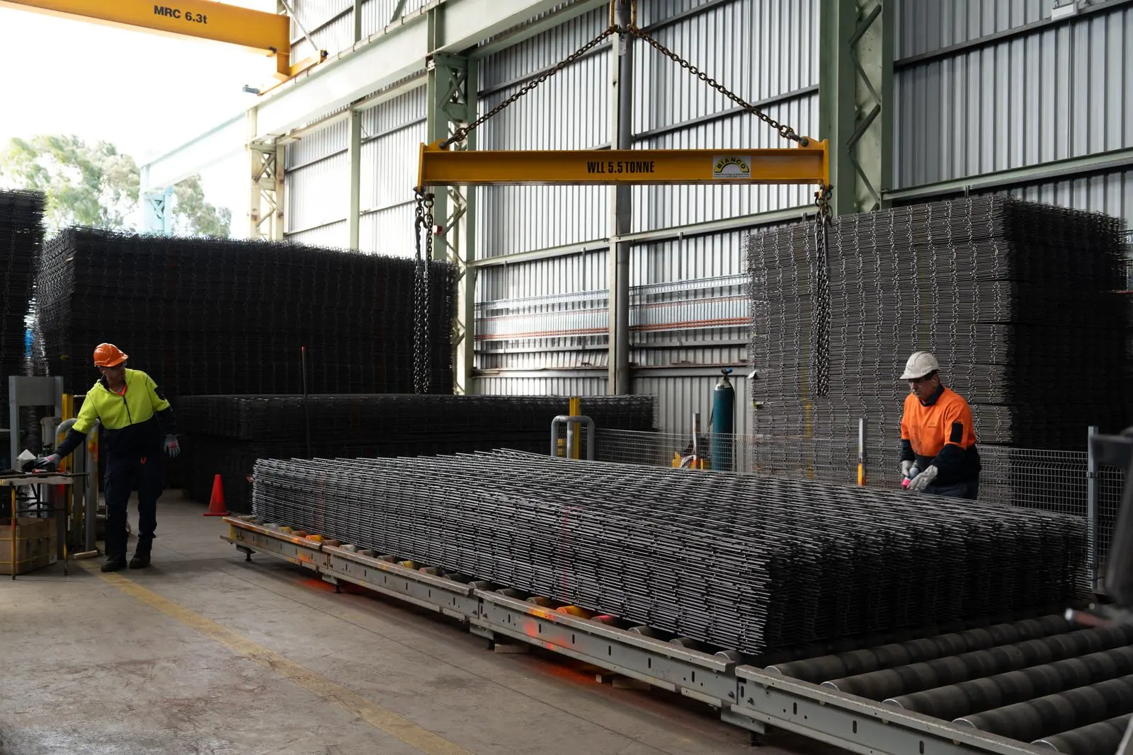 Two Bianco team members working on a stack of reinforcing mesh in the factory