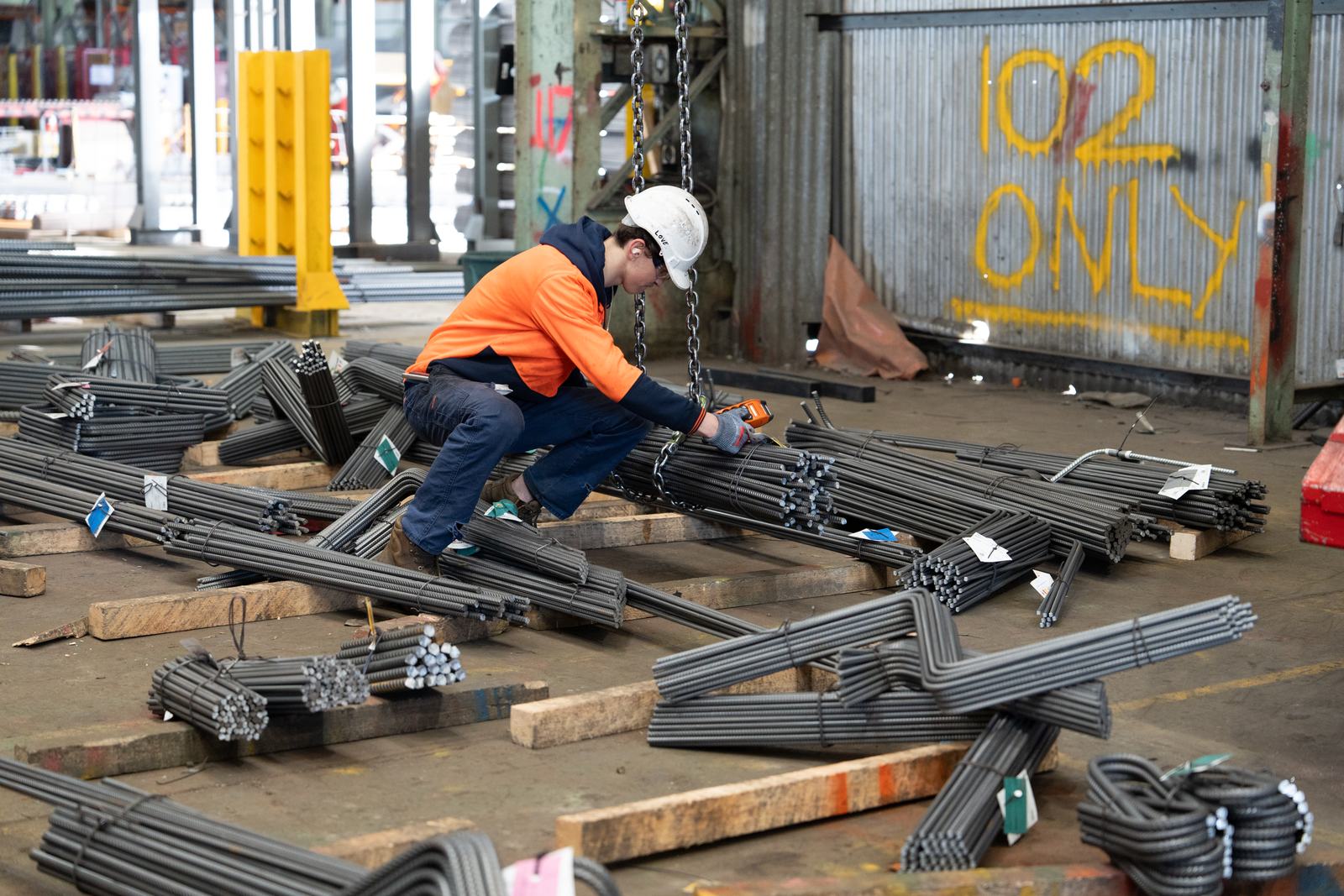Factory worker handling reinforcing bar